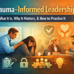 Leader supporting a distressed employee while colleagues collaborate, illustrating trauma-informed leadership in the workplace.